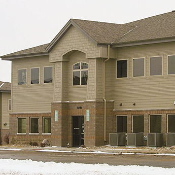 Front view of the Kouri Building, owned by Lon J. Kouri, at 6805 S Minnesota Ave, Sioux Falls, SD. It's a 2-story commercial construction with a beautiful 1/2 brick and 1/2 light tan siding exterior.