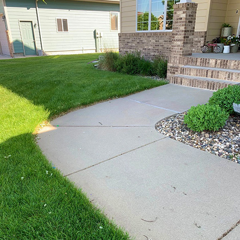 Concrete-Lifting-Example-2 Grass view of a path leading to the front door demonstrating a quality concrete walkway