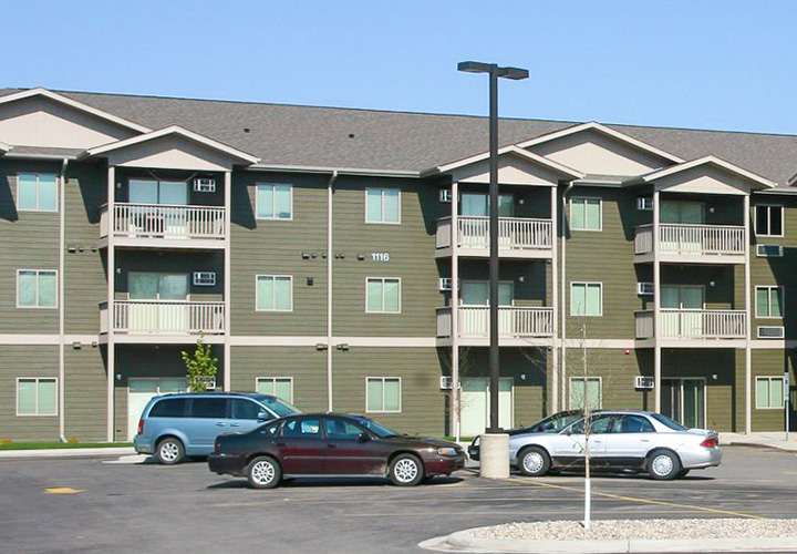 Photo of a green three story multifamily apartment complex