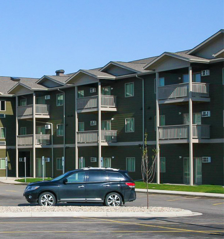 Photo of a green three story multifamily apartment complex