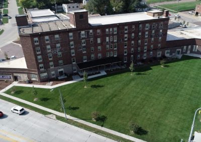 This is an arial view of the Hons Apartment building. It's a 5-story brick building with a large and luxious grass yard.